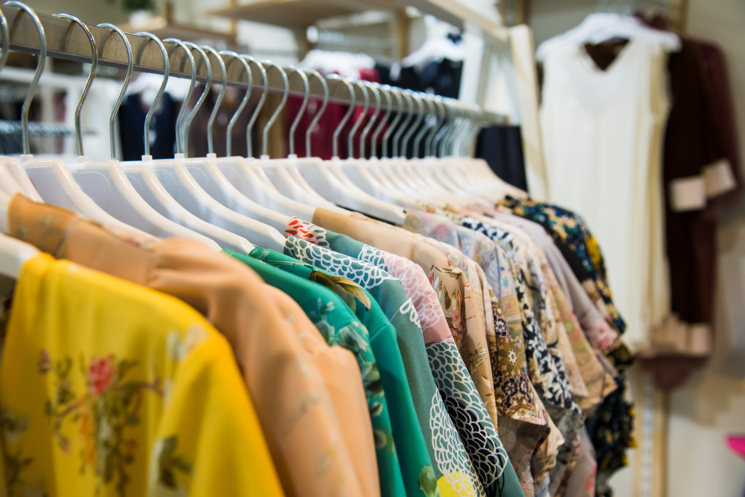 close up of colorful clothes hanging on a rack