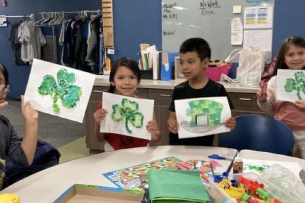 children holding up the cloverleaf artwork